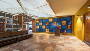 A lobby with a modern design, featuring a seating area, a podium, and a wall with illuminated panels. - Treebo Blue Moon (Gandhinagar)