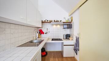 Een koelkast, een microgolfoven, een kookplaat, een eettafel