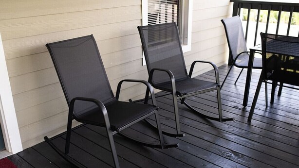 A porch with two rocking chairs and a table. - 7 Minute Walk to Kyle Field - Charming Cottage (College Station)