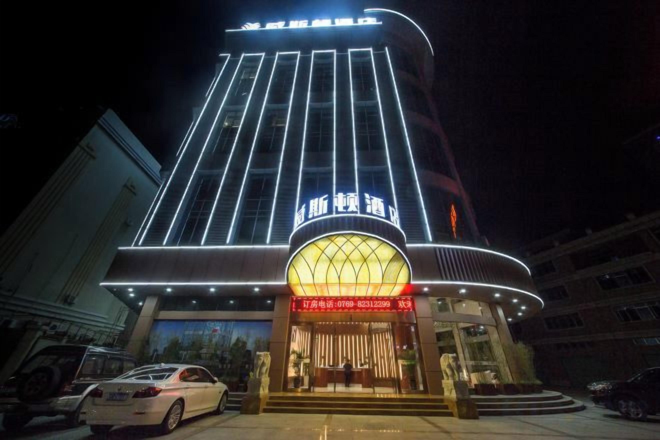 A hotel with a modern facade, illuminated signage, and a prominent entrance.