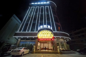 A hotel with a modern facade, illuminated signage, and a prominent entrance. - Weisidun Hotel (Dongguan)