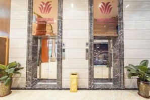 A hotel reception area with marble walls and a reception desk. - Weisidun Hotel (Dongguan)