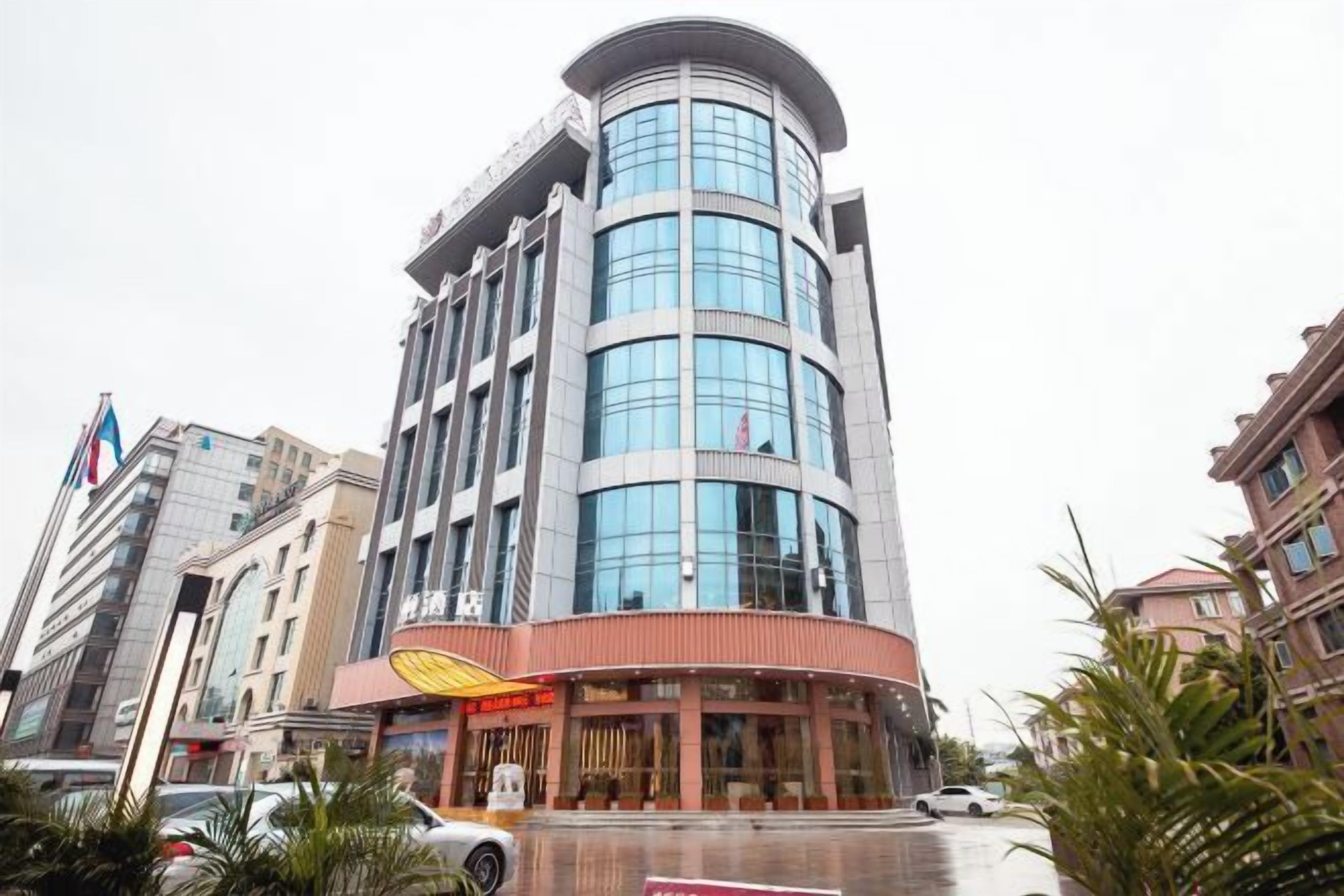 A multi-story hotel with a curved facade, large windows, and a prominent entrance with a yellow awning.