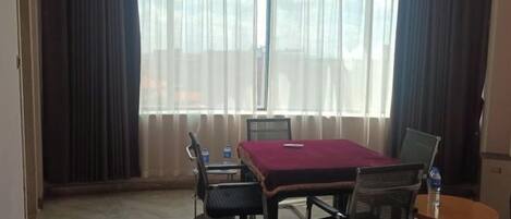 A conference room with a glass table, chairs, a laptop, and a water bottle.