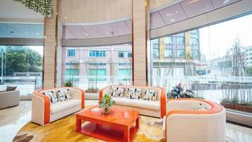 Un vestíbulo moderno con una zona de estar curvada, una mesa de centro y amplios ventanales con vistas al exterior.