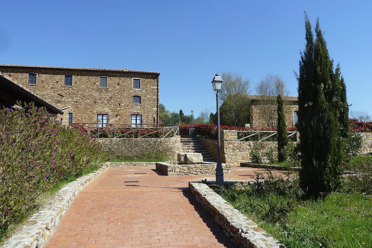 A stone building with a brick pathway leading to a staircase.