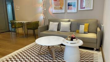A modern living room with a sofa, two chairs, a coffee table, and a patterned rug.