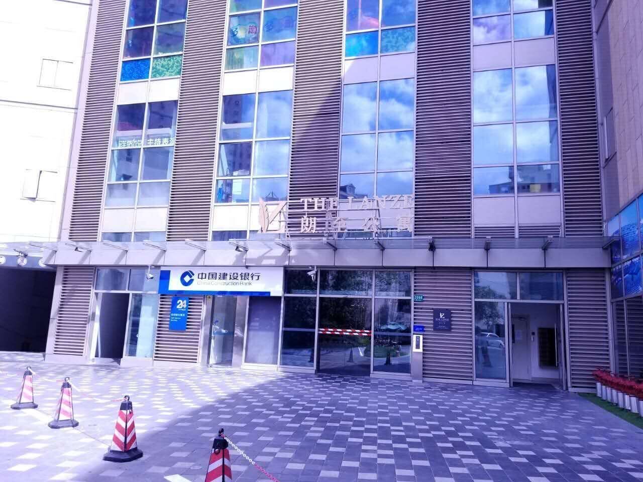 A modern building with large windows and a sign for the China Construction Bank.