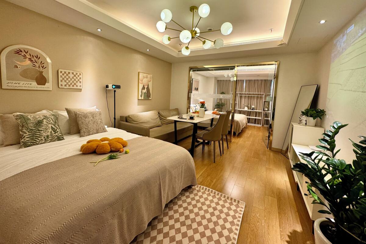 Une chambre d’hôtel moderne, dotée d’un grand lit, d’un bureau et d’un coin repas.