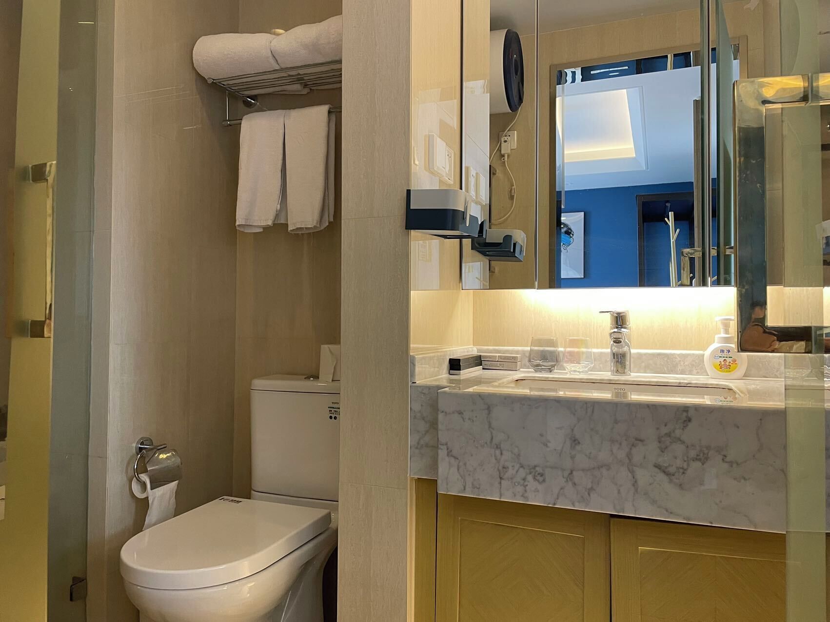 A modern bathroom with a toilet, sink, and mirror.