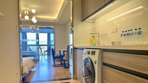 Een moderne hotelkamer met een wasmachine, een eethoek en een balkon met uitzicht.