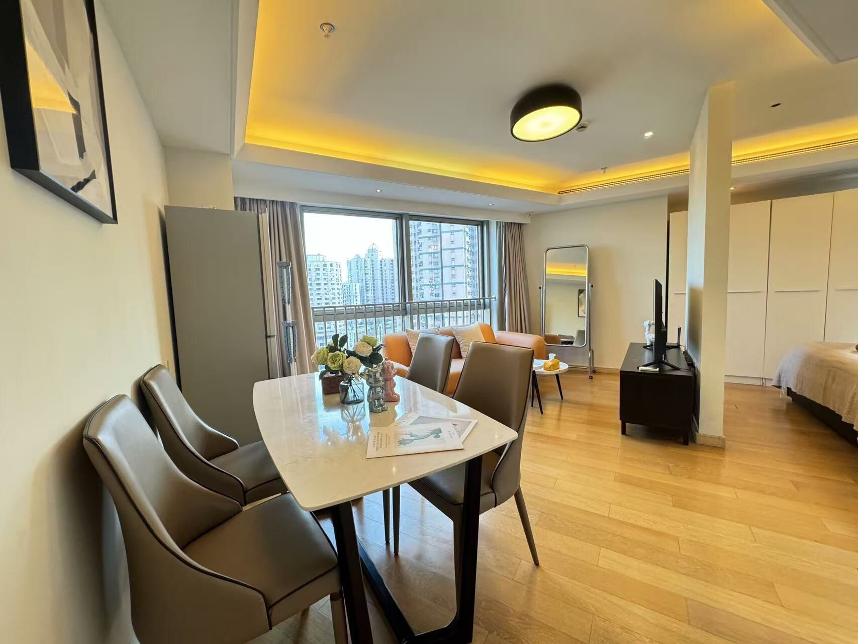 Ein modernes Hotelzimmer mit Essbereich, einem Bett und einem Fernseher.