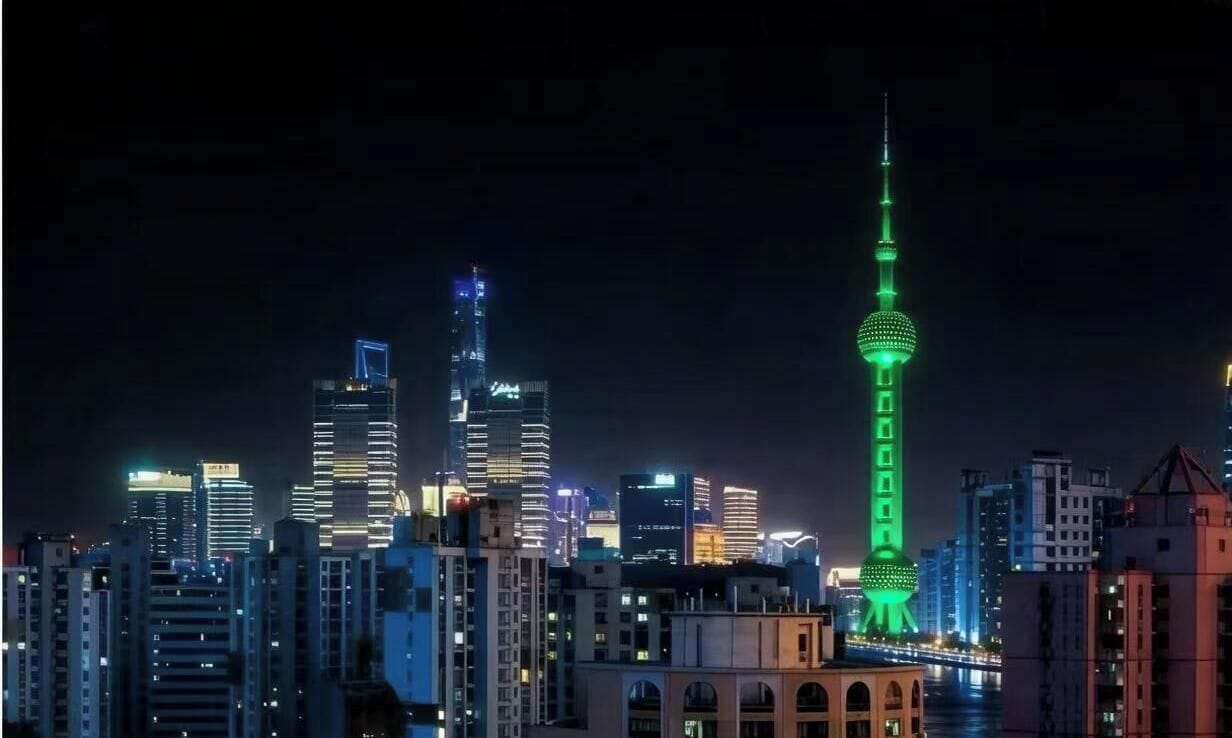 Un paisaje urbano nocturno con edificios iluminados y una torre destacada.