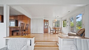 Amplia sala de estar con cocina, mesa de comedor y asientos.