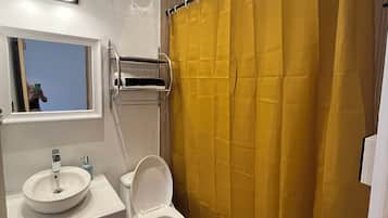 Chuveiro, toalhas de banho, sabonete, papel higiênico