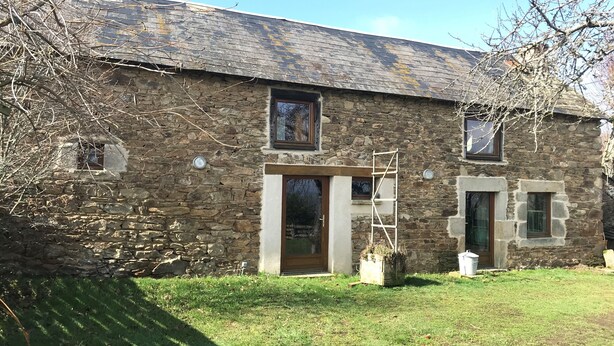 A stone building with a wooden door, a window, and a ladder. - Farm cottage (Sainte-Christine)