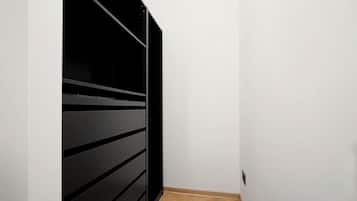 A narrow hallway with a black sliding door on the left and a white wall on the right.
