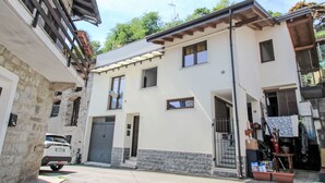 A two-story building with a stone facade, a garage, and a small shop on the ground floor. - Il Covo Felice by Interhome (Gravellona Toce)