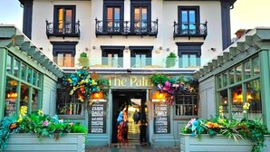 Un edificio de dos pisos con un letrero que dice "The Pal".