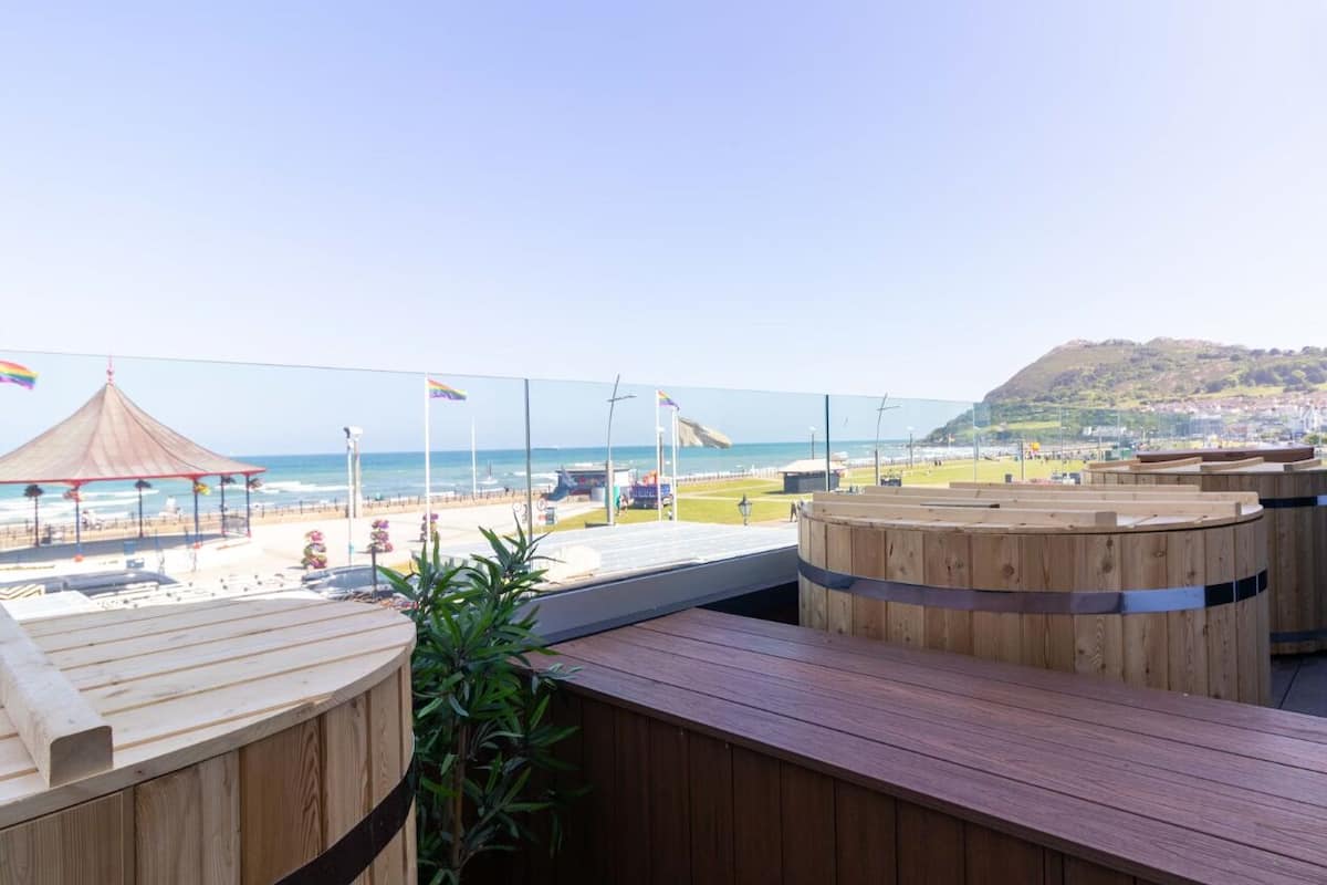 A wooden deck with a view of the beach and ocean.