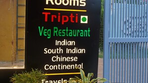 Schild des Hotel Anant Inn, das luxuriöse Zimmer, Tripti und ein vegetarisches Restaurant mit indischer, südindischer, chinesischer und kontinentaler Küche bewirbt.