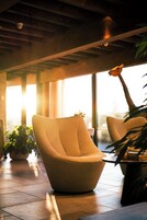 Un interior moderno con un sillón redondo y texturizado y una planta en maceta.