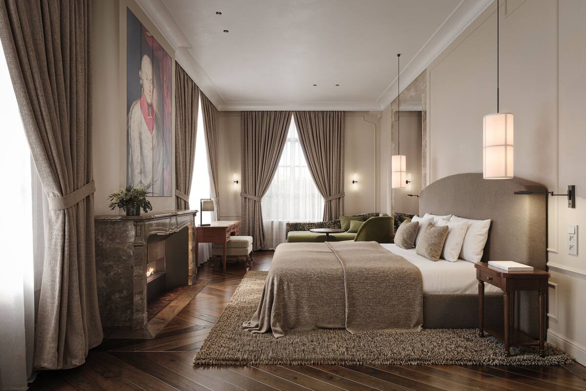 Une chambre spacieuse avec un grand lit, une cheminée, un canapé vert et un tableau au mur.