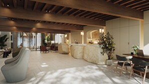 Un hall d’entrée spacieux avec un plafond haut, des poutres en bois et un espace détente comprenant des canapés et des fauteuils.