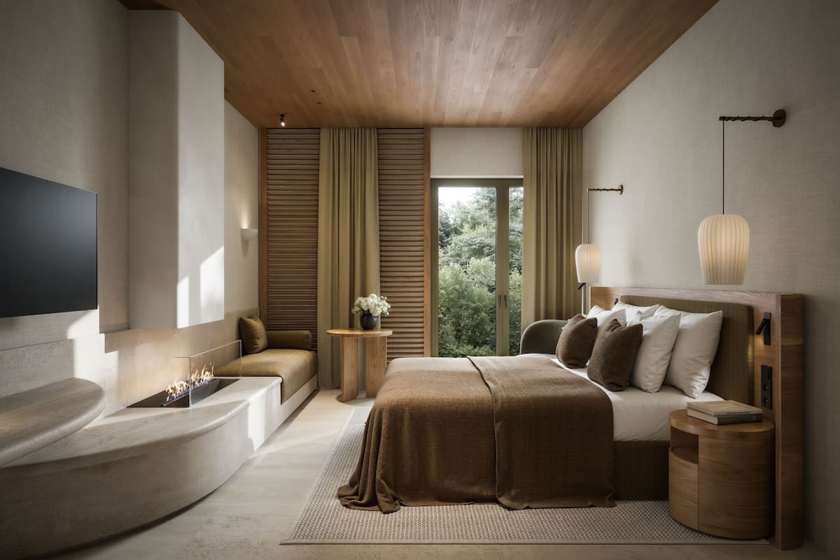 Une chambre à coucher moderne avec un grand lit, une baignoire intégrée et un téléviseur fixé au mur.