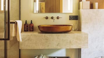 Un baño moderno con un espejo grande, un lavabo de madera y un perchero para toallas.