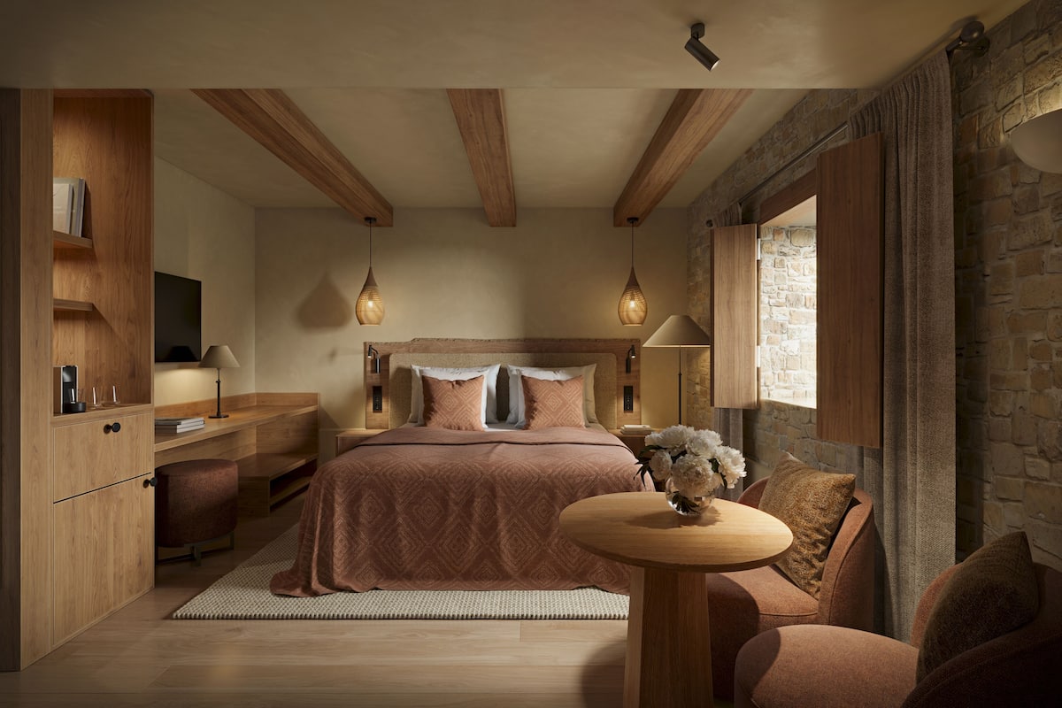 Une chambre à coucher avec un lit, des tables de chevet, un bureau et une fenêtre avec des rideaux.