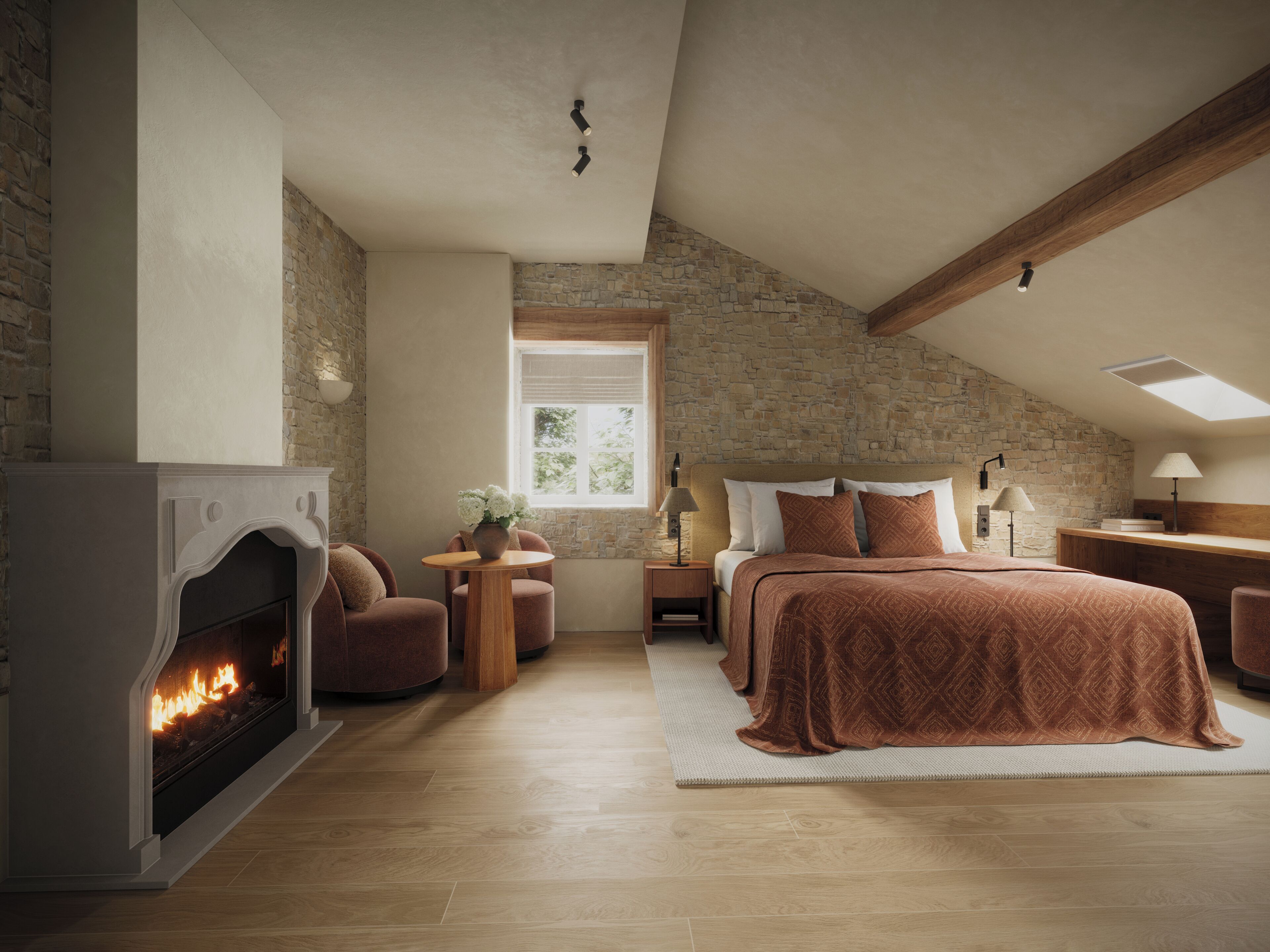 Une chambre confortable avec une cheminée, un grand lit, un mur en pierre et une fenêtre de toit.