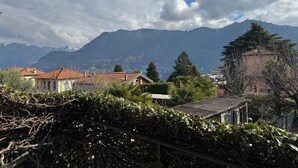 Paisagem montanhosa com edifícios em primeiro plano e céu claro.