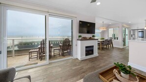 A spacious living area with a fireplace, a flat-screen TV, and a balcony with outdoor seating. - Panoramic Ocean View Huge Rooftop Deck - Sleeps 8 (San Diego)