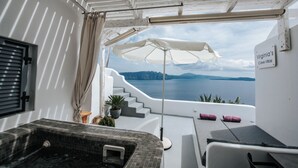A balcony with a view of the sea, a hot tub, and a sign reading "Virginia's Cave Villas".