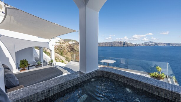 Ein Dachpool mit Infinity-Kante, Blick auf das Meer und die Klippen, ein überdachter Sitzbereich mit Pflanzen und ein modernes architektonisches Design.