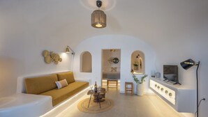 Ein modernes Wohnzimmer mit einer Couch, einem Couchtisch, einem Fernseher und einem Essbereich.