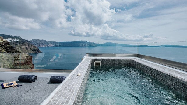 A rooftop infinity pool with a clear view of the sea and mountains. - Grand Cave Villa with Outdoor Hot Tub (Thira - Santorini)