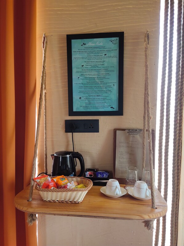 Ein Zimmer mit Schaukelstuhl, einer Snack-Auswahl, einem Wasserkocher und einer Speisekarte an der Wand.
