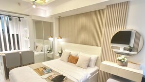 A modern hotel room with a large bed, bedside tables, a desk, and a television. - Cozy studio in beautiful San Fernando with AC, WiFi and Pet Friendly  (San Fernando)