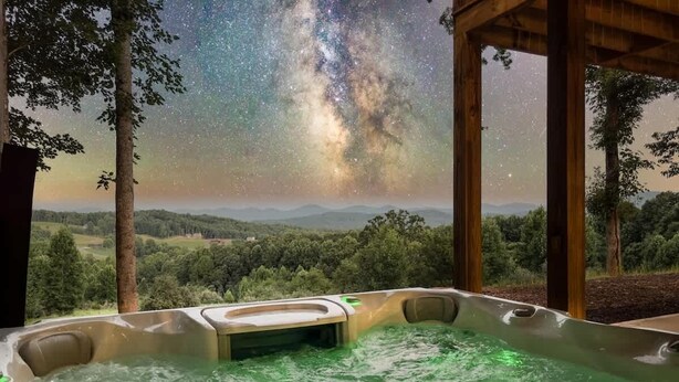 A hot tub with a view of the Milky Way, surrounded by trees and a wooden structure. - Berry Refined - Luxury, views, hot tub, spacious (Morganton)