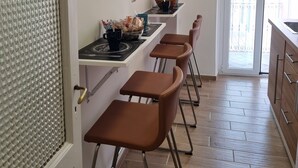 Una cocina con comedor, piso de madera y vista al exterior por una puerta.