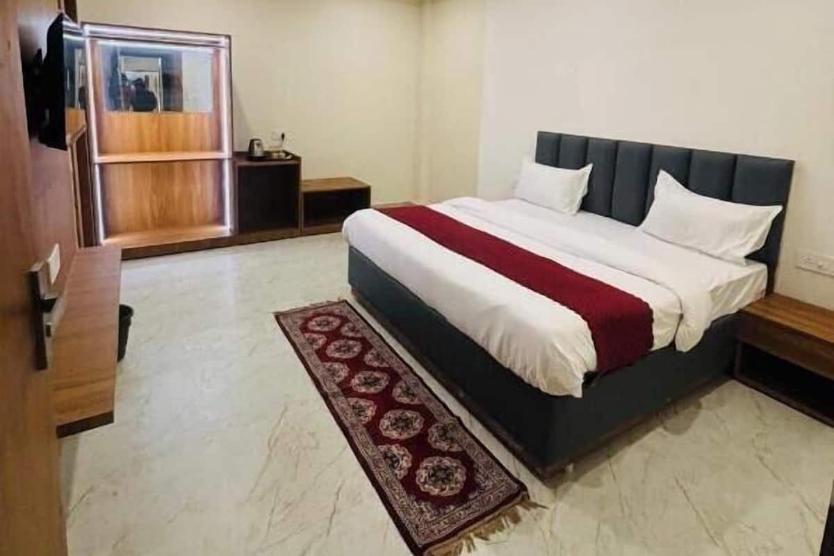 A bedroom with a bed, nightstands, a ceiling fan, and a wooden wardrobe.