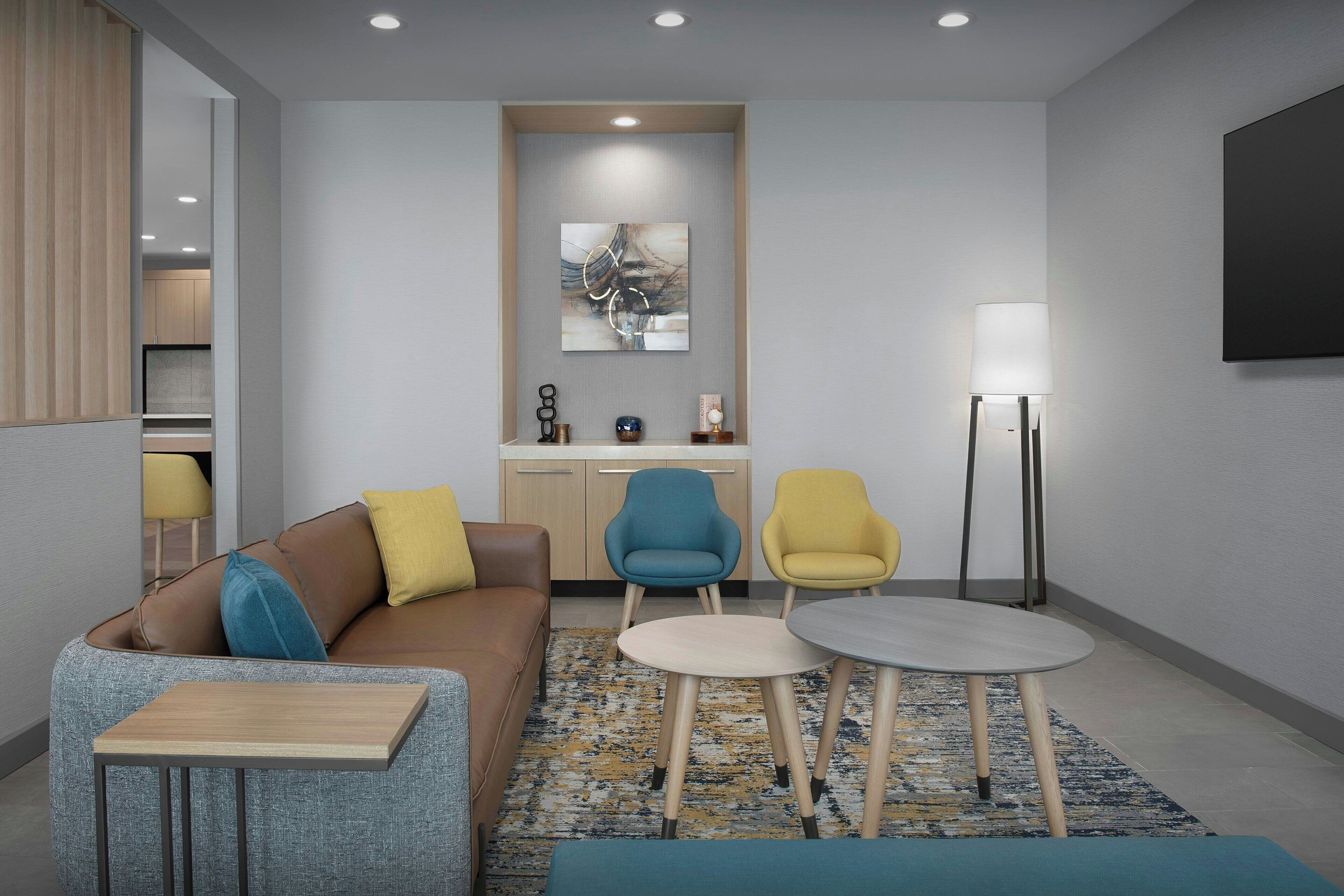 A modern living room with a sofa, two armchairs, a coffee table, and a floor lamp.