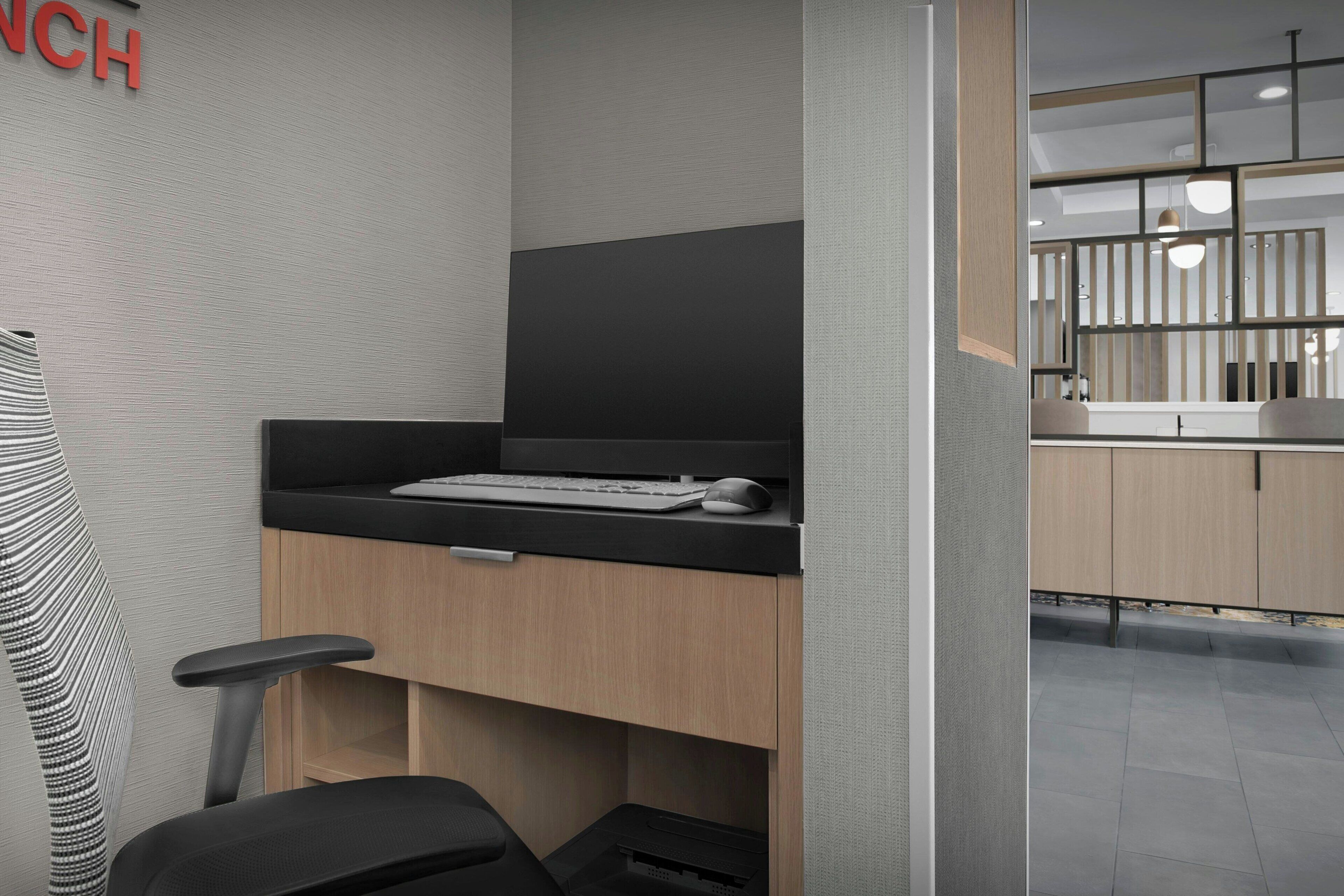 A modern office space with a desk, chair, and a computer setup.
