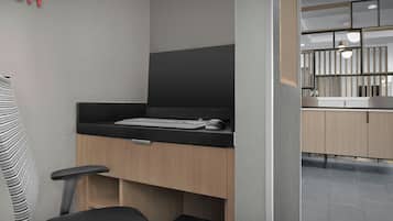 A modern office space with a desk, chair, and a computer setup.