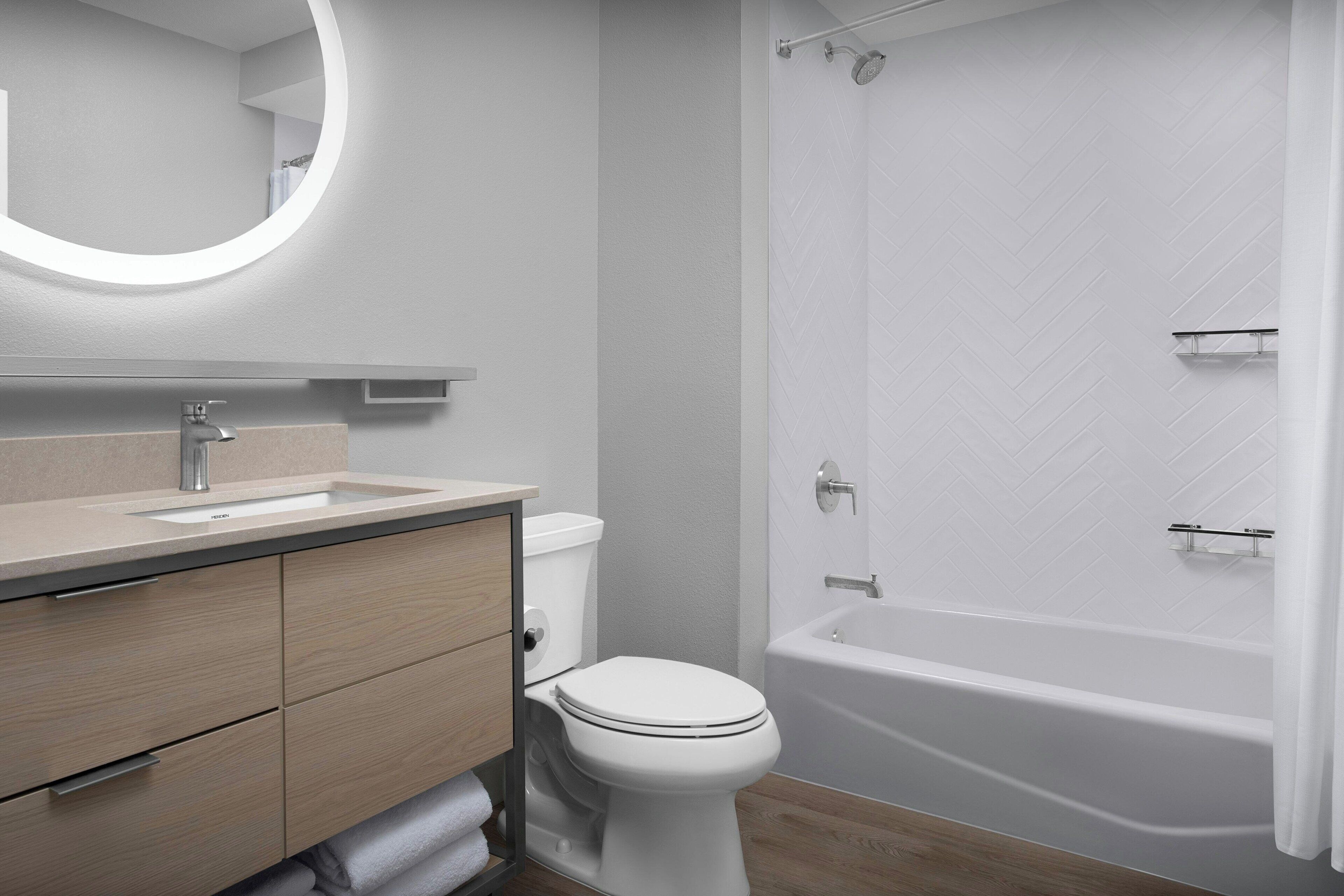 Ein modernes Badezimmer mit Toilette, Waschbecken, Waschtisch und Badewanne.