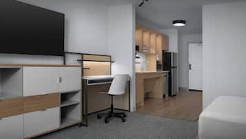 A modern, compact room with a desk, chair, kitchenette, and a bed.