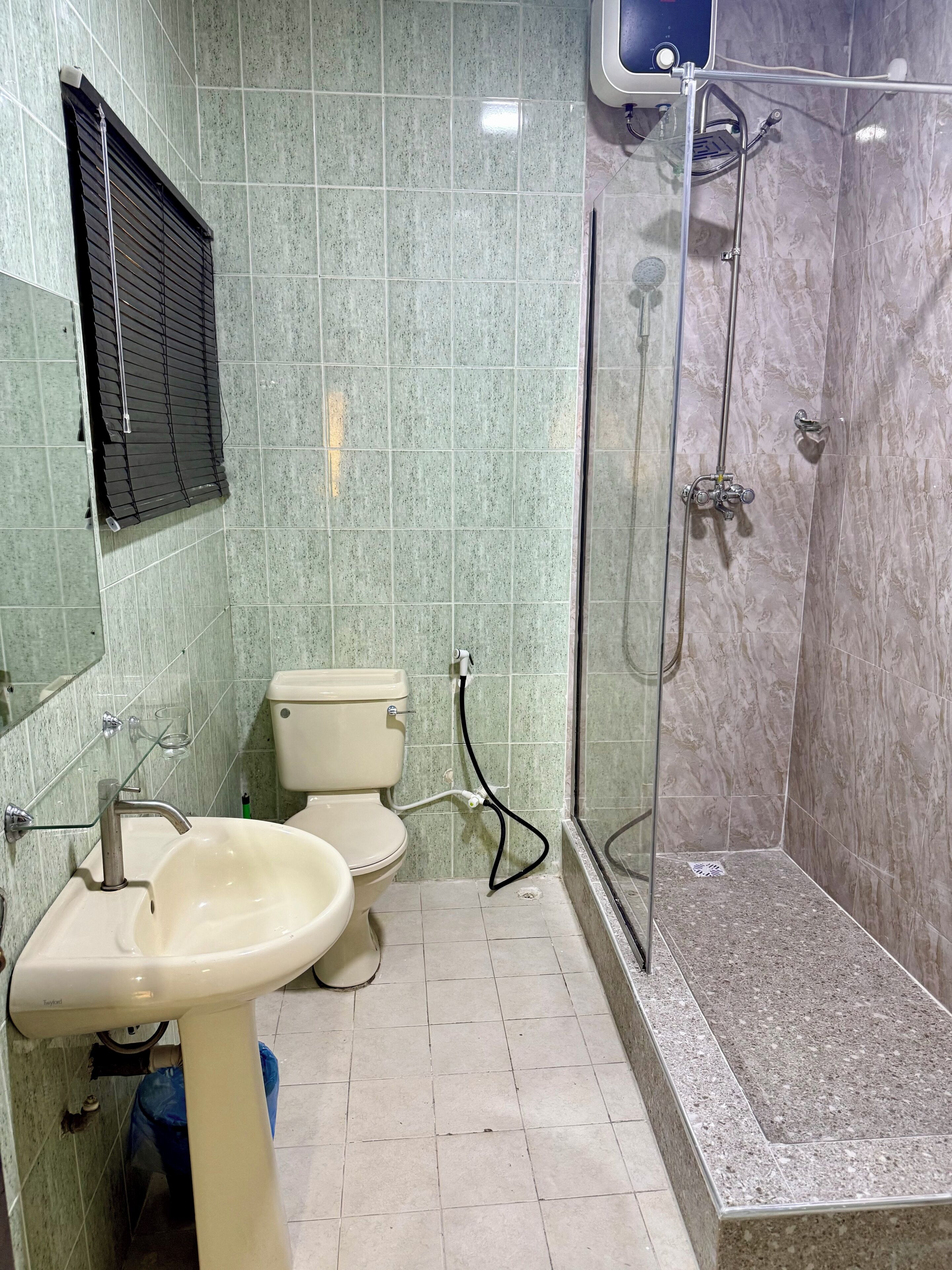 A bathroom with a toilet, sink, and shower.