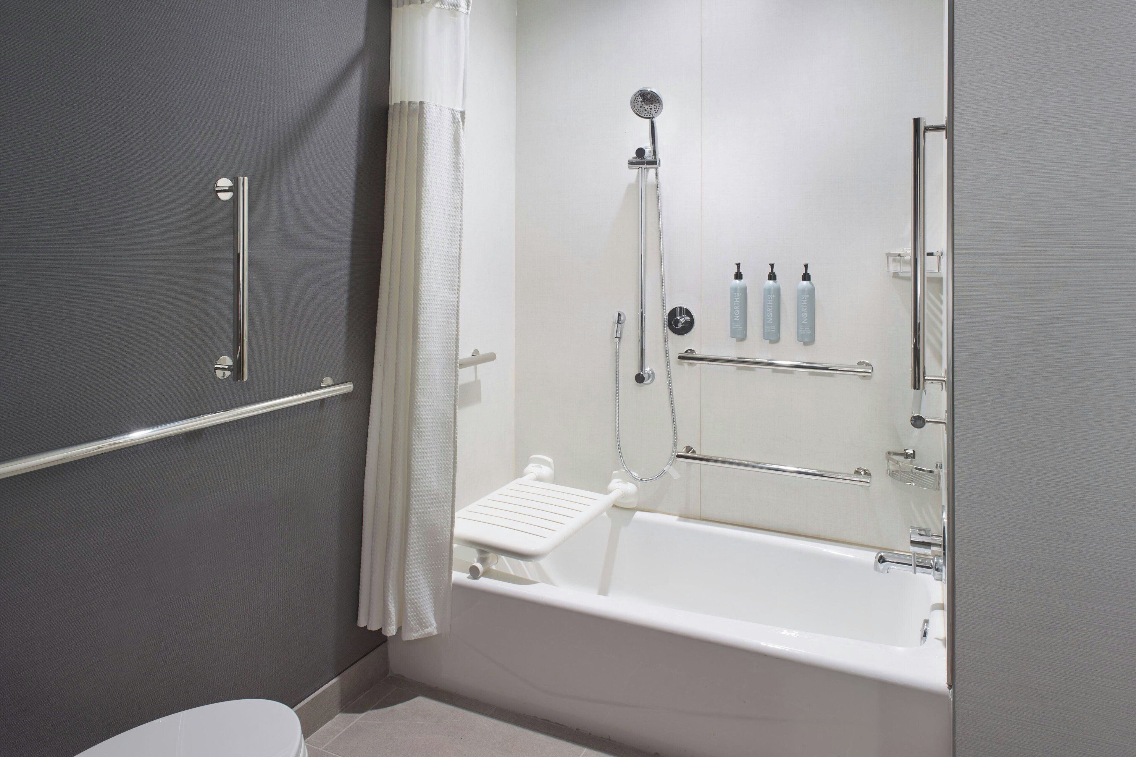 Un baño moderno con bañera, ducha e inodoro.